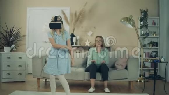 小女孩戴着VR眼镜在奶奶旁边跳舞视频的预览图