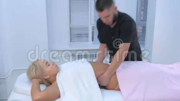 男医生在临床上对女性腰部进行雕塑式身体提拉按摩视频的预览图