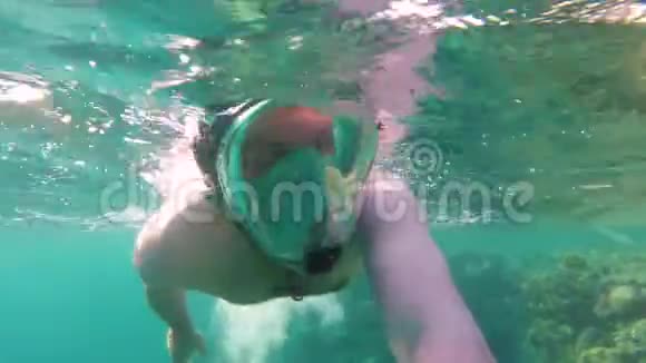 男性义工戴浮潜口罩收集污染海水的胶袋视频的预览图