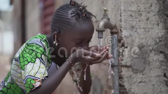 健康和卫生标志黑人少女从自来水中喝干净的水视频的预览图