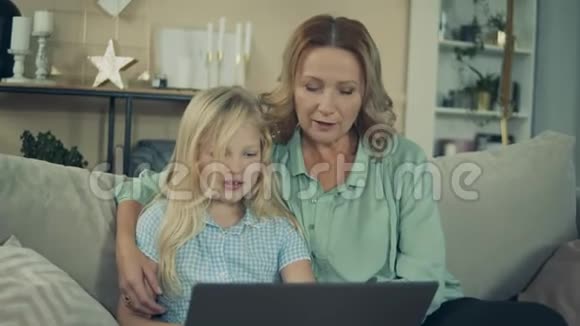 小女孩和她奶奶在笔记本电脑前笑视频的预览图