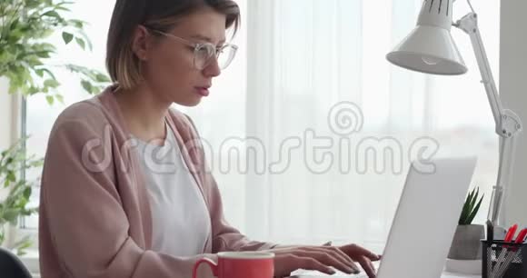 女商人在办公室用笔记本电脑打字视频的预览图