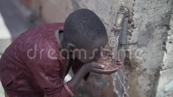 年轻的非洲小学生喝着干净的水贫穷的象征视频的预览图