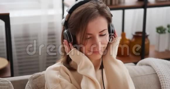 女人在耳机上听音乐视频的预览图