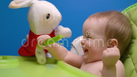 可爱的小女孩吃绿色的新鲜芹菜棒玩兔子娃娃视频的预览图