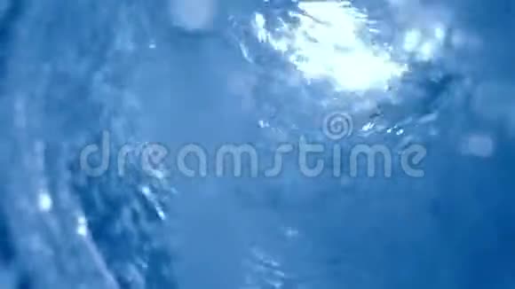 蓝色水滴在纯玻璃内部旋转用慢镜头近距离拍摄视频的预览图
