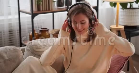 女人在家里用耳机跳舞和听音乐视频的预览图