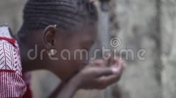 水是非洲儿童的生命小美丽的黑人女孩从水龙头里喝水视频的预览图