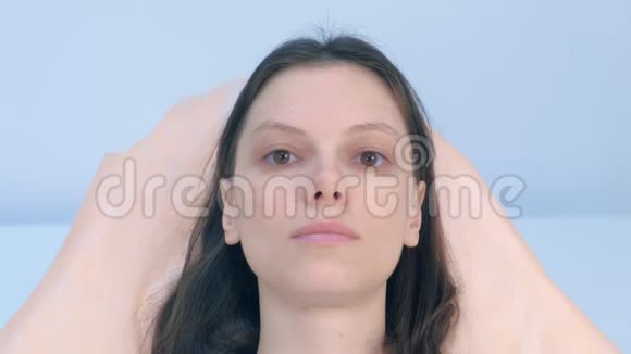 美容诊所里年轻的黑发女人看镜头的肖像视频的预览图