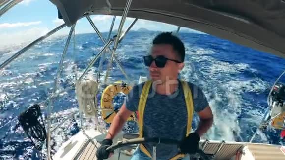 驾驶帆船时戴太阳镜的人的正面视频的预览图