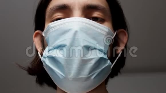 戴着外科口罩的人的近距离头部视频的预览图