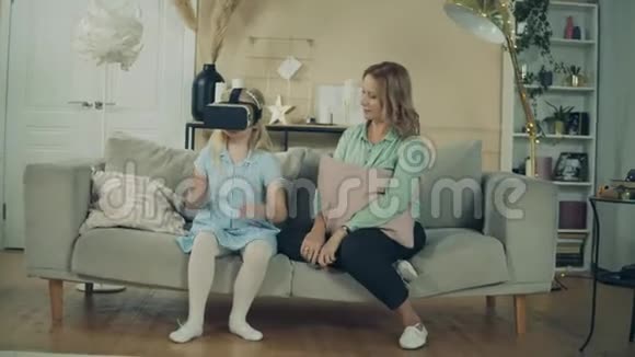 奶奶正在和一个戴着VR眼镜的小女孩玩耍视频的预览图