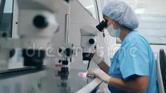 女性医生在人工受精过程中使用医学显微镜科学上的人工授精视频的预览图