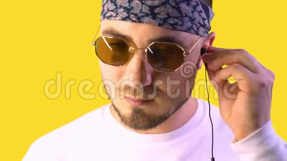 时髦的年轻人戴着时髦的眼镜戴着听音乐的耳机视频的预览图