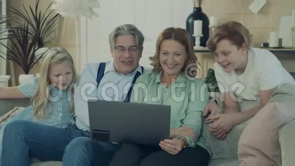 孩子们和爷爷奶奶一起浏览笔记本电脑视频的预览图