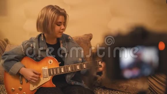 一个年轻的女孩博客删除了学习弹吉他的vlog一名青少年正在为社交网络录制视频视频的预览图