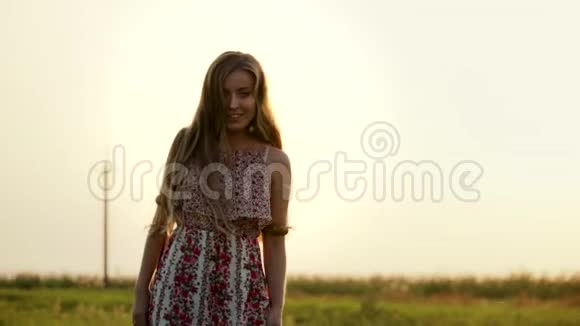 阳光明媚的夏日傍晚一个年轻漂亮的金发女郎穿着一件老式的长裙摆着一个造型她有一台照相机视频的预览图