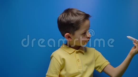 快乐的孩子在蓝底手中玩玩具飞机视频的预览图