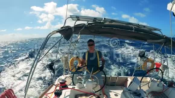 蓝色的大海一个人在帆船上航行由一个年轻人控制的海洋帆船视频的预览图