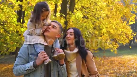 父亲背上的孩子秋天公园的幸福家庭秋天视频的预览图