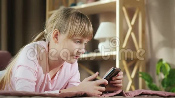儿童侧视在他的房间里使用智能手机视频的预览图