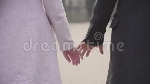 穿着秋装的成年白种人夫妇牵着手沿着公园里的小巷浪漫的男人视频的预览图