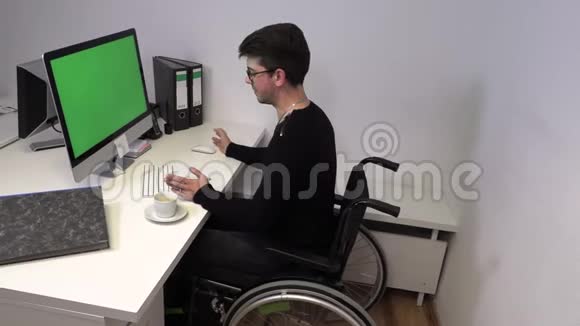 坐轮椅的经理一个不能在工作场所用电脑走路的年轻人动作慢视频的预览图