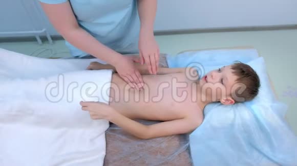医生按摩师在诊所为青少年做腹部按摩视频的预览图