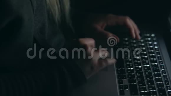 头罩里的黑客在暗室里用笔记本电脑打字视频的预览图