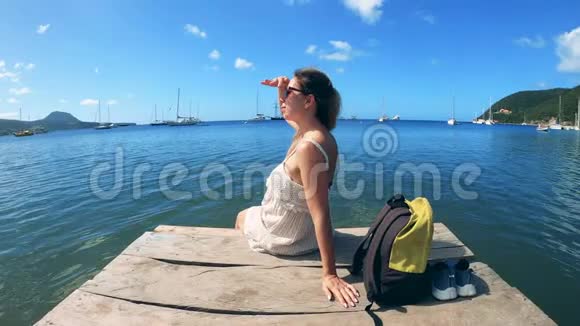 一个女人坐在码头上看着天空视频的预览图