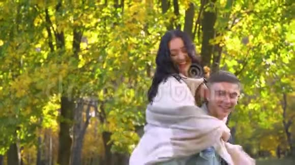 欢笑快乐的家庭快乐的一对在秋天公园玩得开心视频的预览图