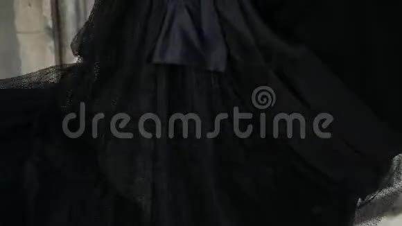 苗条的女孩穿着黑色的裙子在镜头前摆姿势旋转视频的预览图