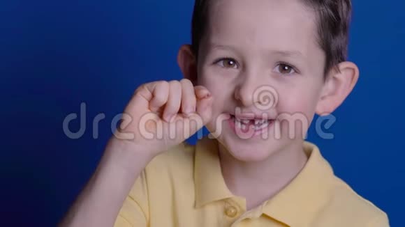 白种人小男孩手指间夹着一颗掉落的乳牙视频的预览图