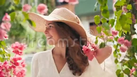 一位戴着一顶大草帽的年轻开朗的白种人女子的肖像视频的预览图
