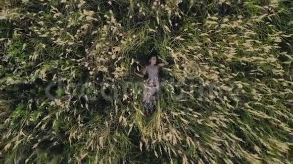 一个女孩模特在四架直升机上围成一圈躺在绿草中的画面视频的预览图
