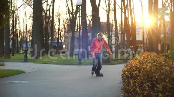 秋天在一个以树木为背景的中央城市公园里酷长胡子的人在溜冰鞋上滑冰和跳舞积极主动视频的预览图