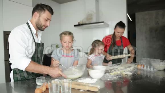 一家四口在厨房里雕刻饺子孩子们帮助父母视频的预览图