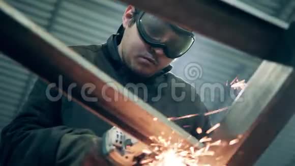 防护眼镜中的焊工正在切割金属产生大量火花视频的预览图