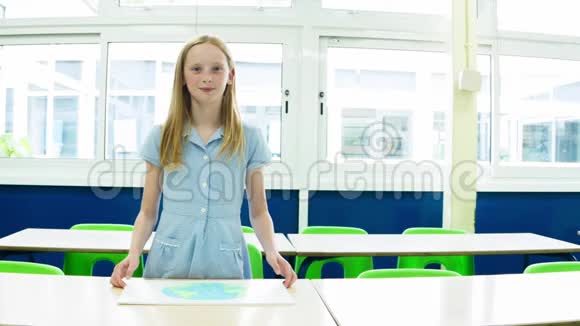 白人小学的女孩举着一个带有地球图像的标语牌视频的预览图