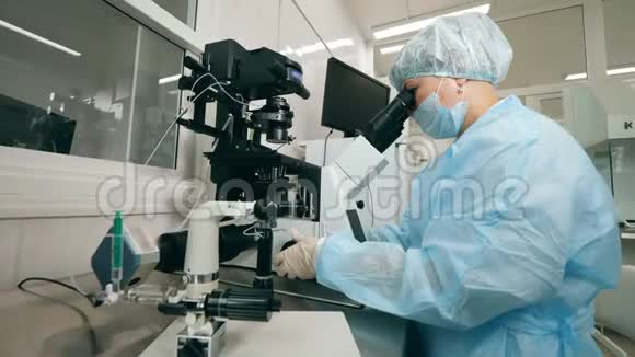 冠状病毒附血症病毒疫苗概念女专家正在实验室里操作显微镜视频的预览图