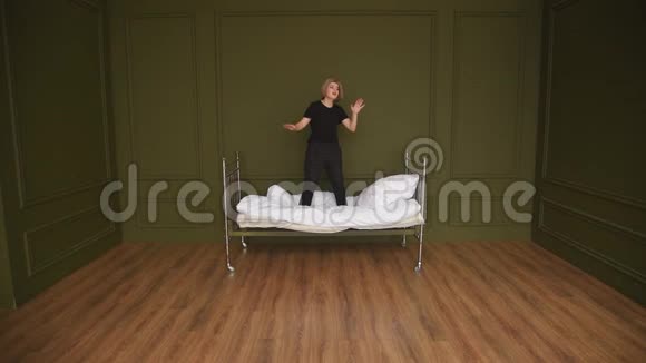 女孩在房间的床上跳舞唱歌拍摄一个片段视频的预览图