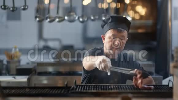 亚洲厨师在餐厅烤烤牛排中镜头4k红色相机视频的预览图