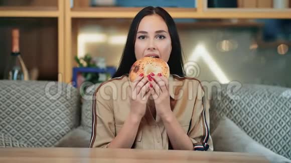 休闲美容女性咬美味开胃蛋糕感觉愉悦中型摄影机视频的预览图