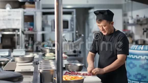 专业的男性厨师在厨房切肉准备食物中型摄影机视频的预览图