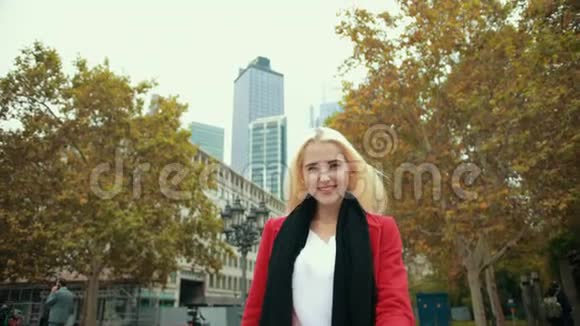 现代都市背景下的金发女孩在镜头前向前转视频的预览图