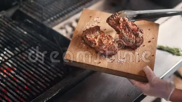 厨师把煎肉放在木板上上面放着草药近距离拍摄4k红色相机视频的预览图