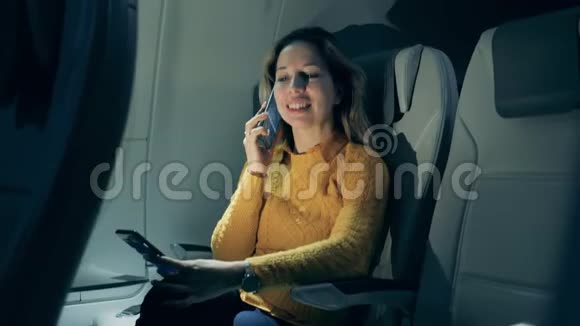 一位女士在飞机舱里打电话视频的预览图