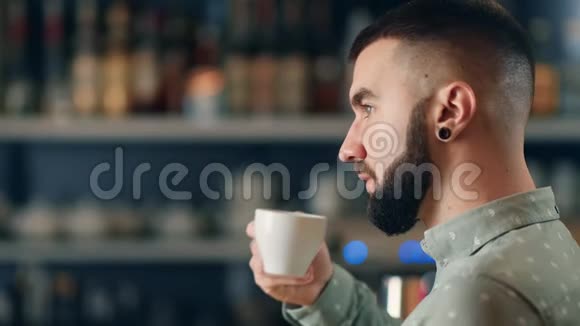 面反光的家伙在餐饮店享受香茶近距离拍摄4k红色相机视频的预览图