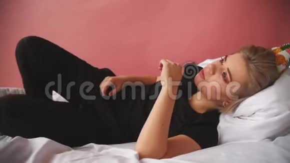 不快乐的女孩唱歌在床上受苦这个女孩过了一个悲伤的生日拍摄一个片段视频的预览图