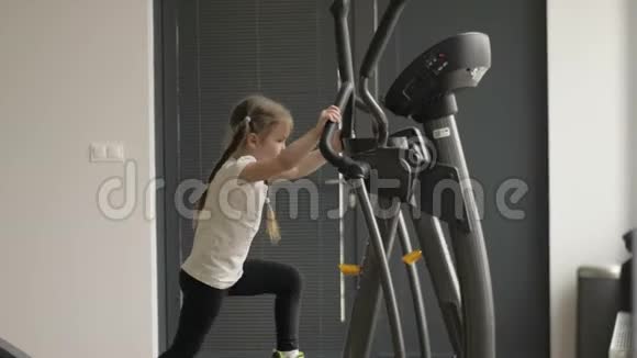 小女孩在健身房里从事健身器材视频的预览图